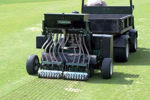 overseeder behind turfco tow introduces golf turf lift level