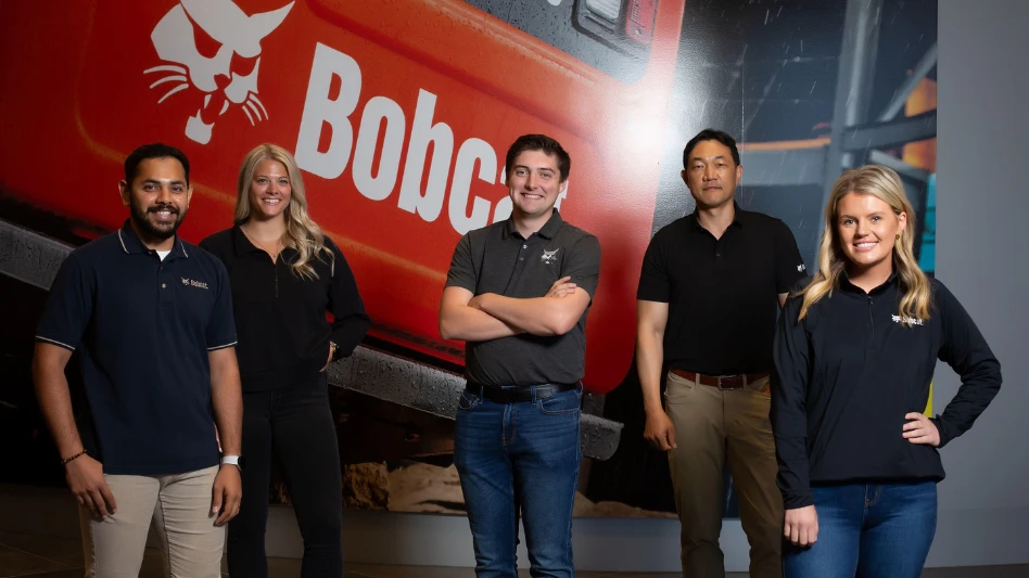 Bobcat employees standing in front of the logo