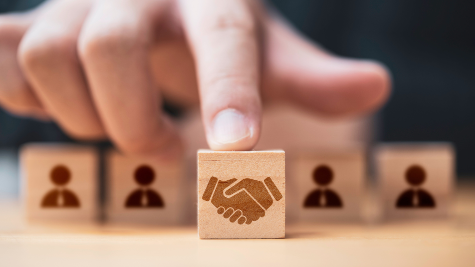 A finger pointing out a block with two hands shaking on a deal.